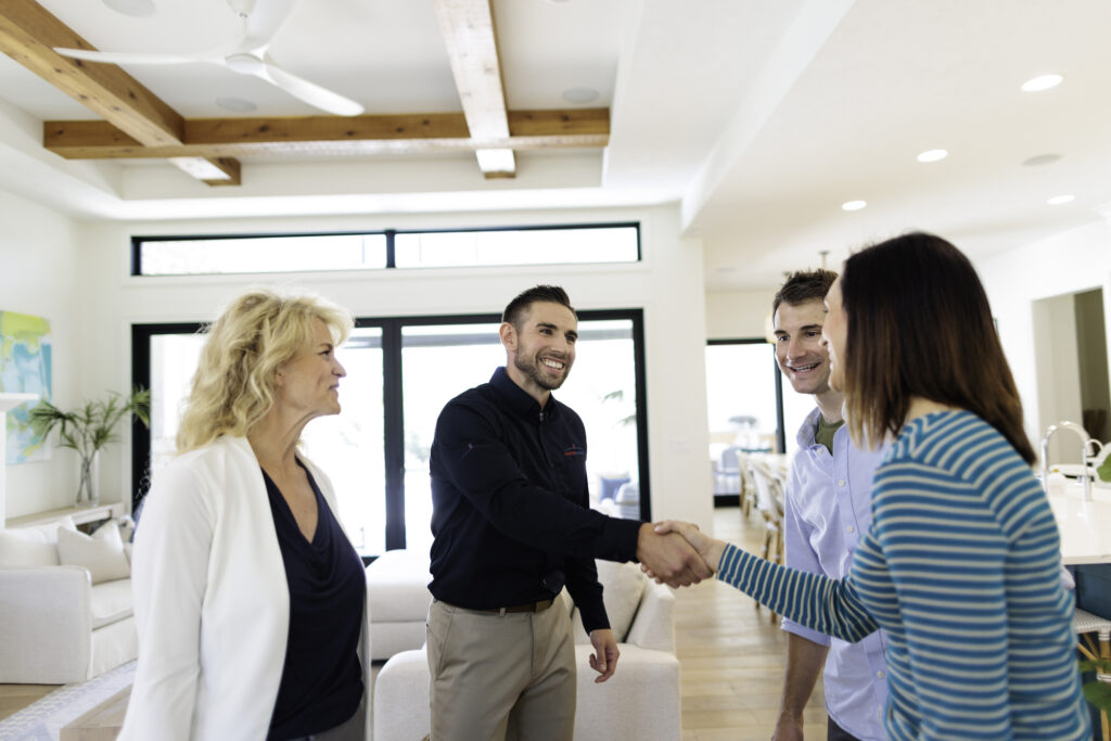 home inspector greeting clients and their real estate agent in the entry of a home